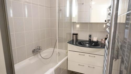 W łazience znajduje się umywalka i wanna. w obiekcie Appartement 556, Vue Mer et piscine By Palmazur Vacances w Cannes