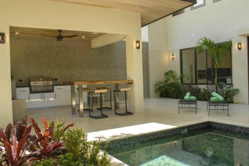 Il comprend une cuisine et un salon avec une piscine. dans l'établissement Casa Kaiman - Villa Azul, à Nosara