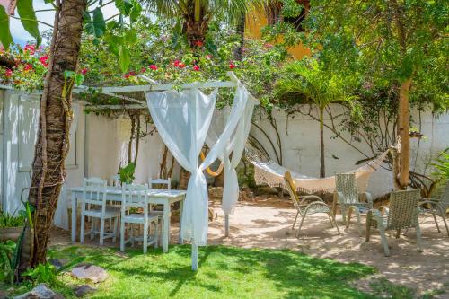 a patio with a table and chairs under a tree at casa jasmin in Jericoacoara