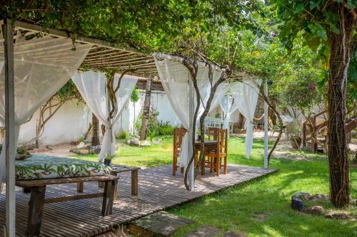a patio with a table and chairs under a pergola at casa jasmin in Jericoacoara