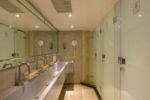 een badkamer met een rij wastafels en spiegels bij WORK INN at Taipei 101 in Taipei