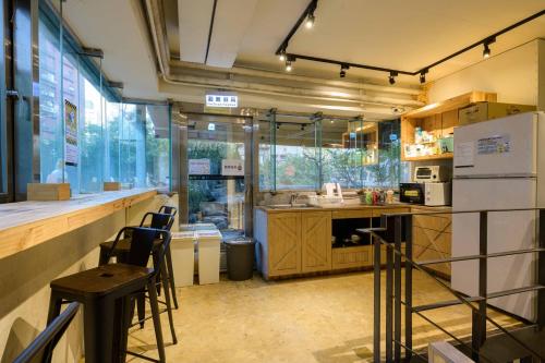a kitchen with a counter and some chairs in it at WORK INN at Taipei 101 in Taipei