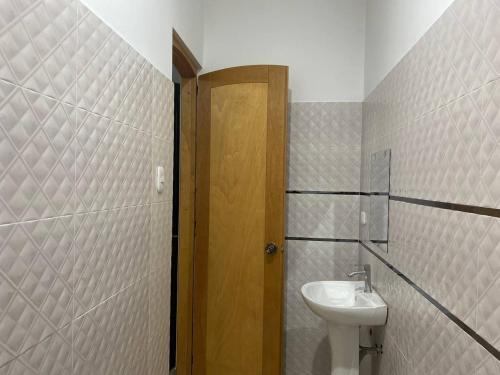 a bathroom with a sink and a toilet and a door at Hotel Los Pajonales in Huaraz