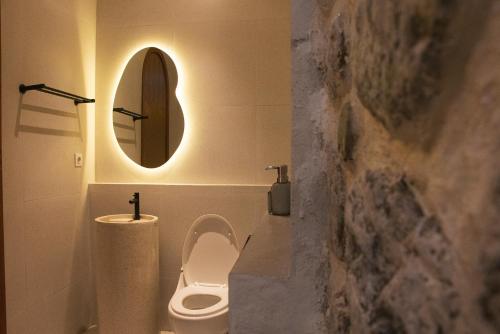 a bathroom with a toilet and a mirror at Villa Soll A By The Villas 100 in Bogor