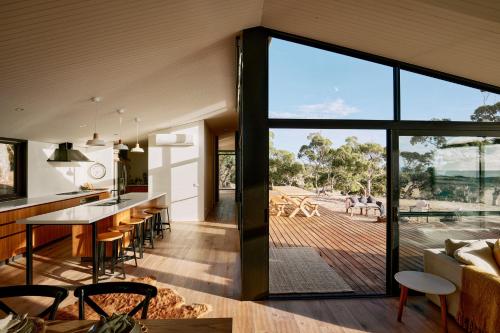 an open kitchen and living room with a large glass window at Luxury Ocean View house Saltbush Farm in Cape Jervis