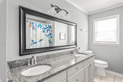 a bathroom with two sinks and a mirror at Charming, Cozy Home close to Uptown, Airport & Whitewater Center in Charlotte