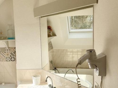 - un miroir de salle de bains avec sèche-cheveux à côté d'un lavabo dans l'établissement Maison Authentique avec Parc, Cheminée et Équipements Modernes au Cœur de la Vallée de la Loire - FR-1-381-468, à Souvigny-de-Touraine