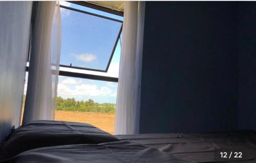 Schlafzimmer mit einem Fenster und Blick auf ein Feld in der Unterkunft Resort flat Gavôa in Igarassu