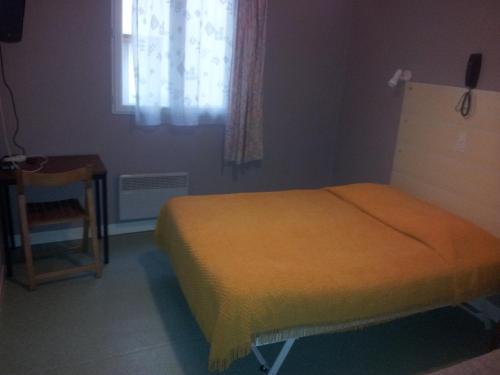 une chambre avec un lit, une table et une fenêtre dans l'établissement Hôtel du Terrage, à Paris