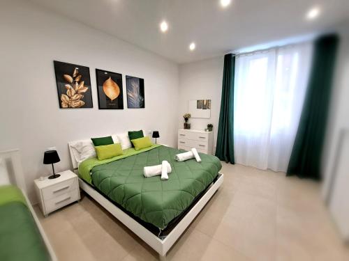 1 dormitorio con 1 cama verde y 2 toallas en Le Popolari - Appartamento, en Bitonto