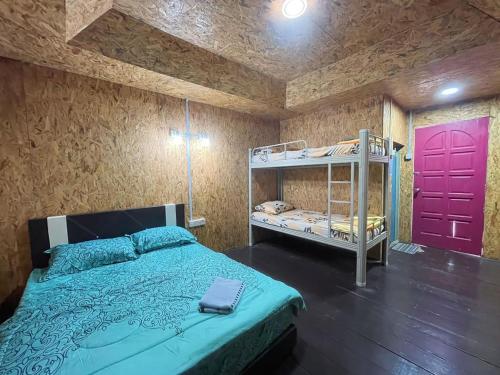 sypialnia z łóżkiem piętrowym i czerwonymi drzwiami w obiekcie Bee Chalet Perhentian Island w mieście Wyspa Perhentian
