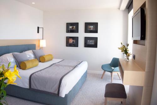 a bedroom with a bed and a desk and a television at Royal Neptun Hotel in Dubrovnik