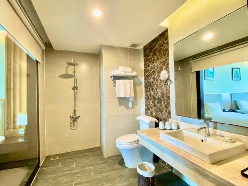 a bathroom with a sink and a toilet and a mirror at Muong Thanh Luxury Buon Ma Thuot Hotel in Buon Ma Thuot