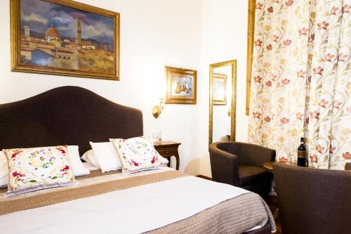 フィレンツェにあるAM Collection Florenceのベッドと椅子付きのホテルルーム