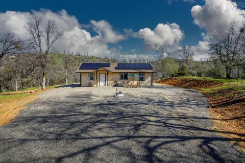 ein Haus mit einem Sonnendach auf einer Straße in der Unterkunft Bear Paw Cabin new construction near Yosemite in Mariposa