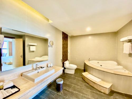 a bathroom with a tub and a toilet and a sink at Muong Thanh Luxury Buon Ma Thuot Hotel in Buon Ma Thuot