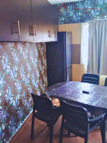 - une salle à manger avec une table, des chaises et un mur dans l'établissement TARIK KHAYER, à Agadir