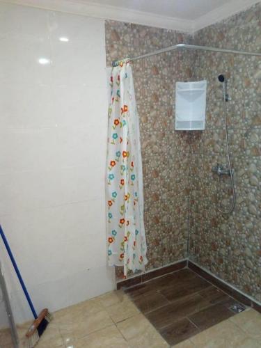 La salle de bains est pourvue d'une douche avec rideau de douche. dans l'établissement TARIK KHAYER, à Agadir