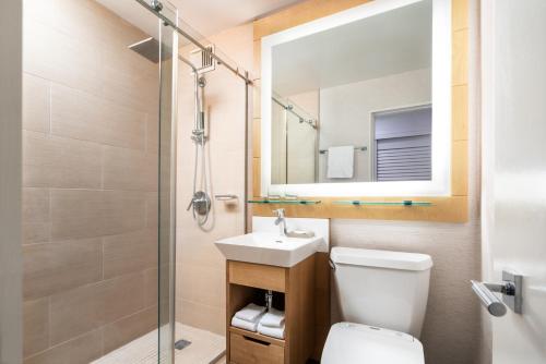 ein Badezimmer mit einem WC, einem Waschbecken und einem Spiegel in der Unterkunft Moana Surfrider, A Westin Resort & Spa, Waikiki Beach in Honolulu