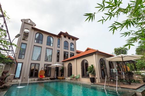 una casa con piscina frente a un edificio en Lan'd villa - Venuestay, en Hanói