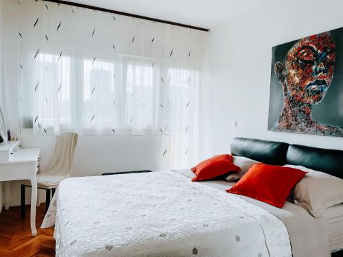 斯普利特的住宿－Apartment Sonja，一间卧室配有一张带红色枕头的大床