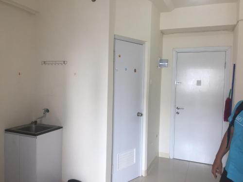 um quarto branco com um lavatório e uma porta em The Green Pramuka em Jacarta