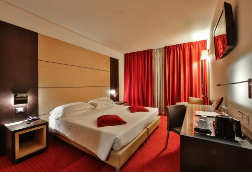 a hotel room with a large bed and a desk at Best Western Plus Hotel Galileo Padova in Padova