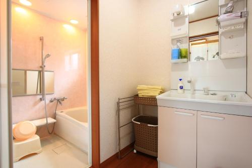 a bathroom with a sink and a toilet and a tub at Yuuwa Guesthouse in Mifune