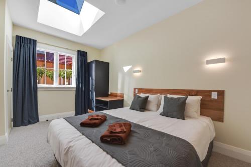 a bedroom with a bed with a pair of slippers on it at Hardy Street School House in Nelson