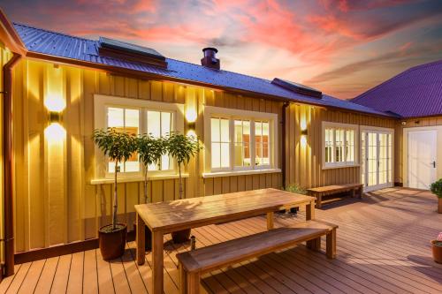 a wooden deck with a bench on a house at Hardy Street School House in Nelson