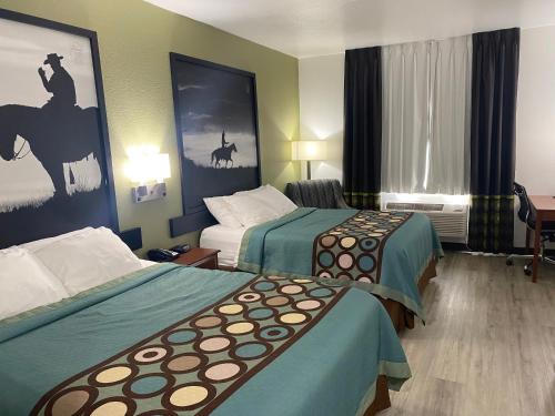 una habitación de hotel con 2 camas en una habitación en Super 8 by Wyndham Weatherford, en Weatherford