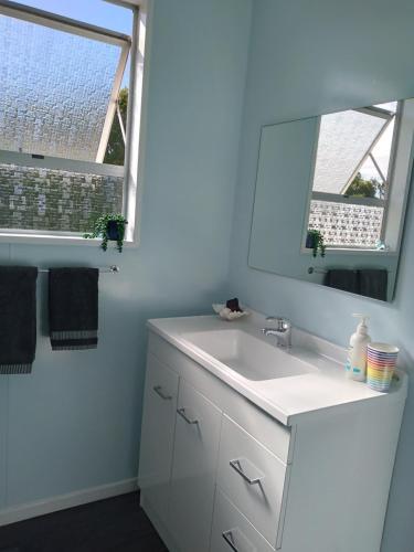 bagno con lavandino bianco e specchio di My Place a Hokitika