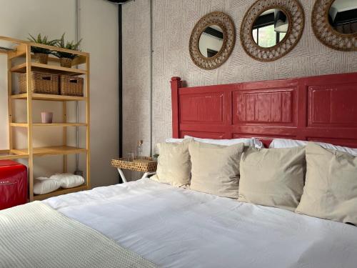 a bedroom with a bed with a red headboard and mirrors at Casa en corazón de la colonia roma Jacuzzi in Mexico City