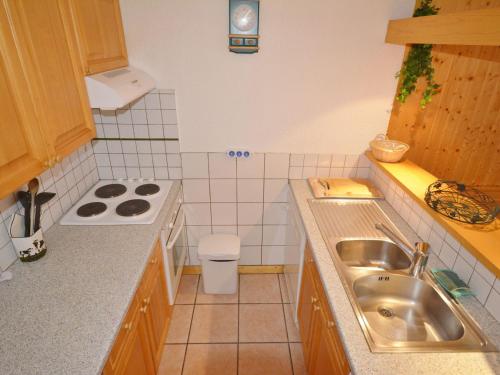 une petite cuisine avec un évier et une cuisinière dans l'établissement Appartement T3 au Centre de Morzine, Proche Pistes, Balcon Exposé Sud, Parking et Casier à Skis - FR-1-684-2, à Morzine