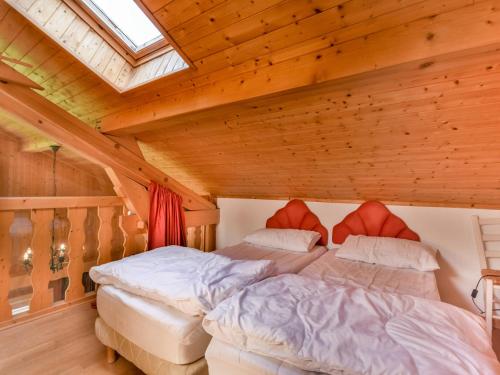 deux lits dans une chambre avec un plafond en bois dans l'établissement Chalet Papillon - 8 pers - À deux pas du Lac des Ecoles et des pistes de ski - FR-1-685-4, aux Gets