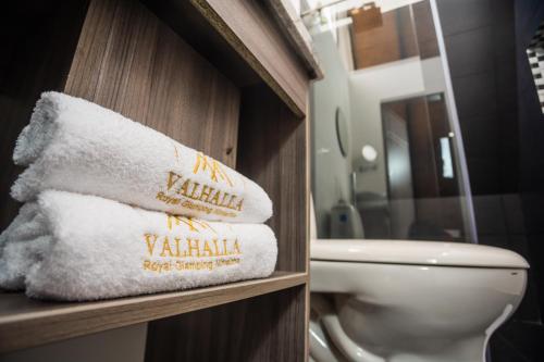 a pile of towels in a bathroom with a toilet at Valhalla Nimaima Glamping in Nimaima