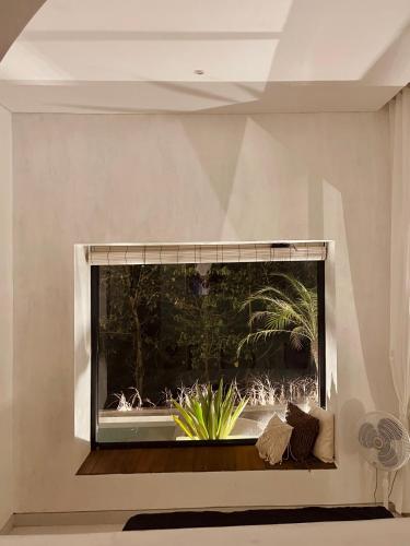 a large window in a wall with a plant in it at Villa Soll B By The Villas 100 in Bogor
