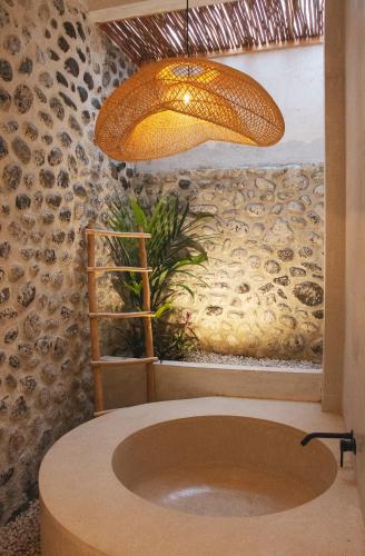 a bathroom with a sink and a potted plant at Villa Soll B By The Villas 100 in Bogor