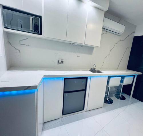 a white kitchen with a sink and a microwave at Departamento ejecutivo nuevo in Ciudad Obregón