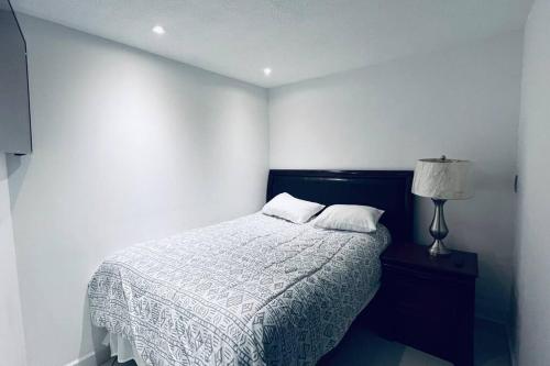 a white bedroom with a bed and a lamp at Departamento ejecutivo nuevo in Ciudad Obregón