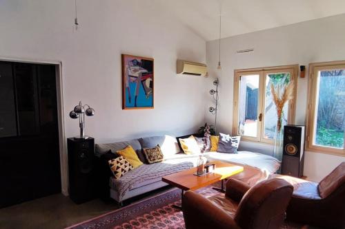 een woonkamer met een bank en een tafel bij Charmante petite villa avec piscine in Claira