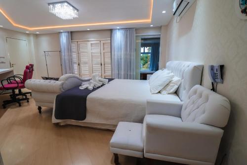 a bedroom with a bed and two chairs and a couch at Paraíso do Salto in Lages