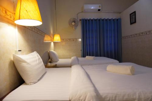 a hotel room with two beds and a blue curtain at Le Tonle in Kratie