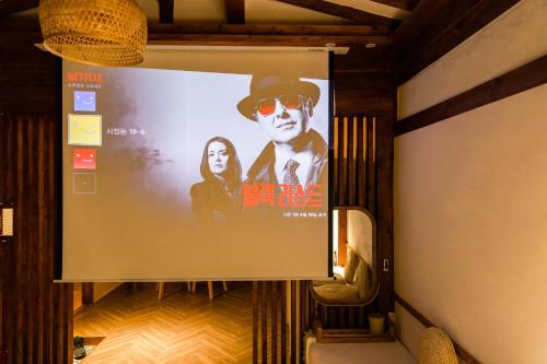 a large screen with a movie on it in a room at EL House in Gyeongju