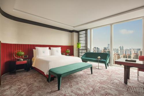 a bedroom with a bed and a large window at Regent Shanghai Pudong - Complimentary first round minibar per stay - including a bottle of wine in Shanghai