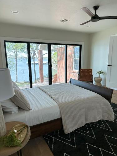 a bedroom with a large bed with a large window at Newly Renovated 4B, 2.5 bath Lakefront home with South Grand Lake Views and dock in Vinita