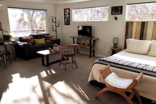 a bedroom with a bed and a living room at Spacious upstairs studio with kitchenette & 1 bath in Grants Pass