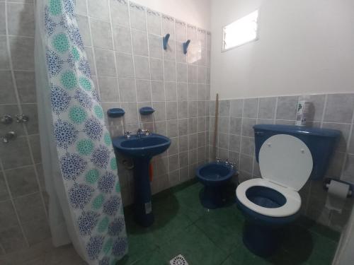 ein Badezimmer mit einem blauen WC und einem Waschbecken in der Unterkunft Hospedaje Ale in Iruya