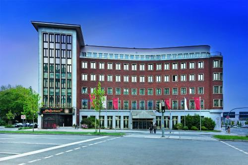 ein großes Backsteingebäude mit einer Straße davor in der Unterkunft Hotel Excelsior Dortmund Hauptbahnhof in Dortmund