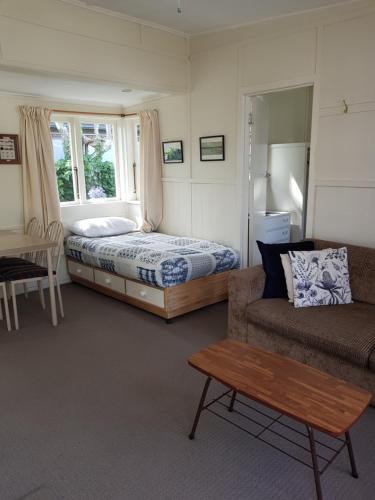 a bedroom with a bed and a couch and a table at Waitahanui Lodge in Waitahanui